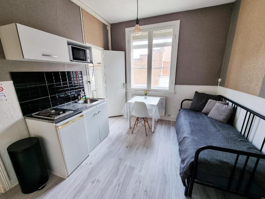 Il dispose d'une cuisine et d'un salon avec un canapé et une table. dans l'établissement Studio du théâtre, à Saint-Omer
