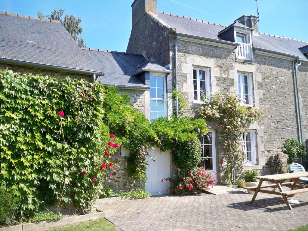 a stone house with a bench in front of it at Gite de La Caminais in Pleurtuit