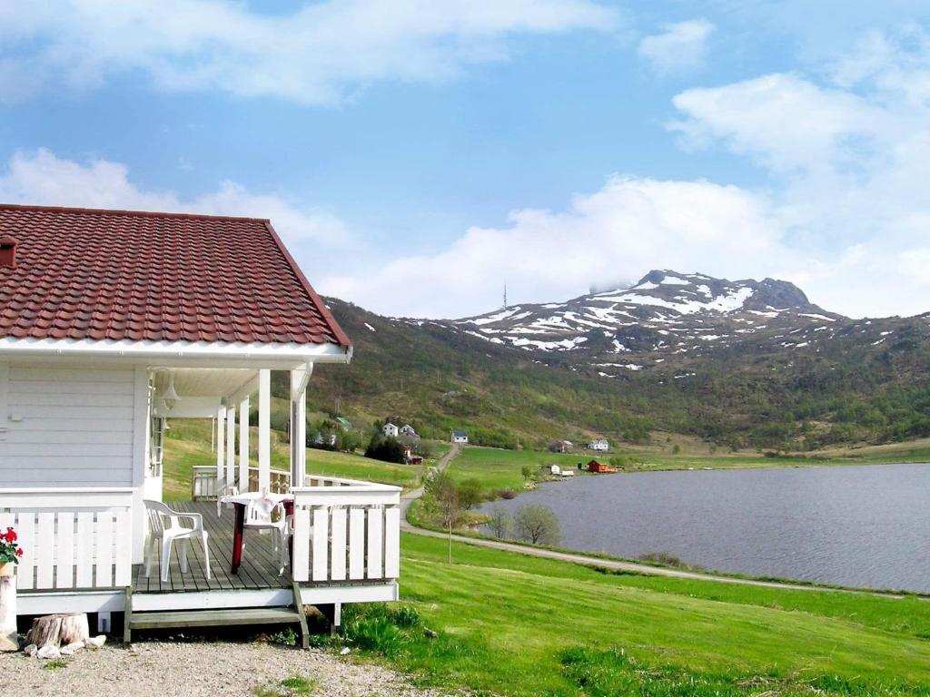 AlstadにあるThree-Bedroom Holiday home in Leknes 1の湖と山の景色を望む白い家