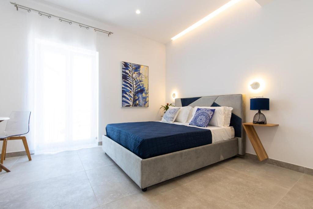 a bedroom with a bed and a desk and a window at Baia Flegrea Meublè in Bacoli