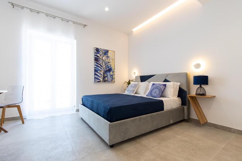 Schlafzimmer mit einem Bett, einem Schreibtisch und einem Fenster in der Unterkunft Baia Flegrea Meublè in Bacoli