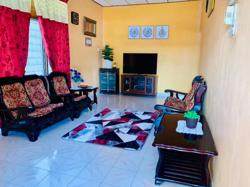 ein Wohnzimmer mit 2 Sofas und einem TV in der Unterkunft Ramizu Homestay Pokok Sena in Pokok Sena