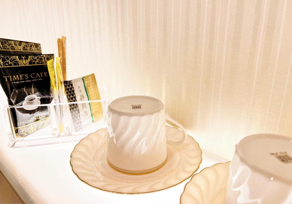 a white blender sitting on a table with a plate at Hotel mond omiya in Saitama