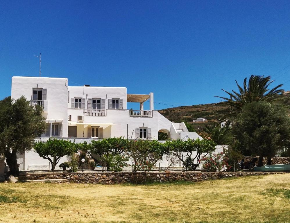 una gran casa blanca con árboles delante de ella en Margaritari Studios Sifnos, en Platis Yialos Sifnos