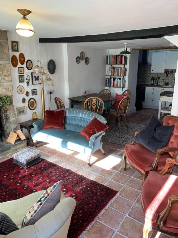 a living room with a blue couch and chairs at Charming townhouse in Bruton in Bruton