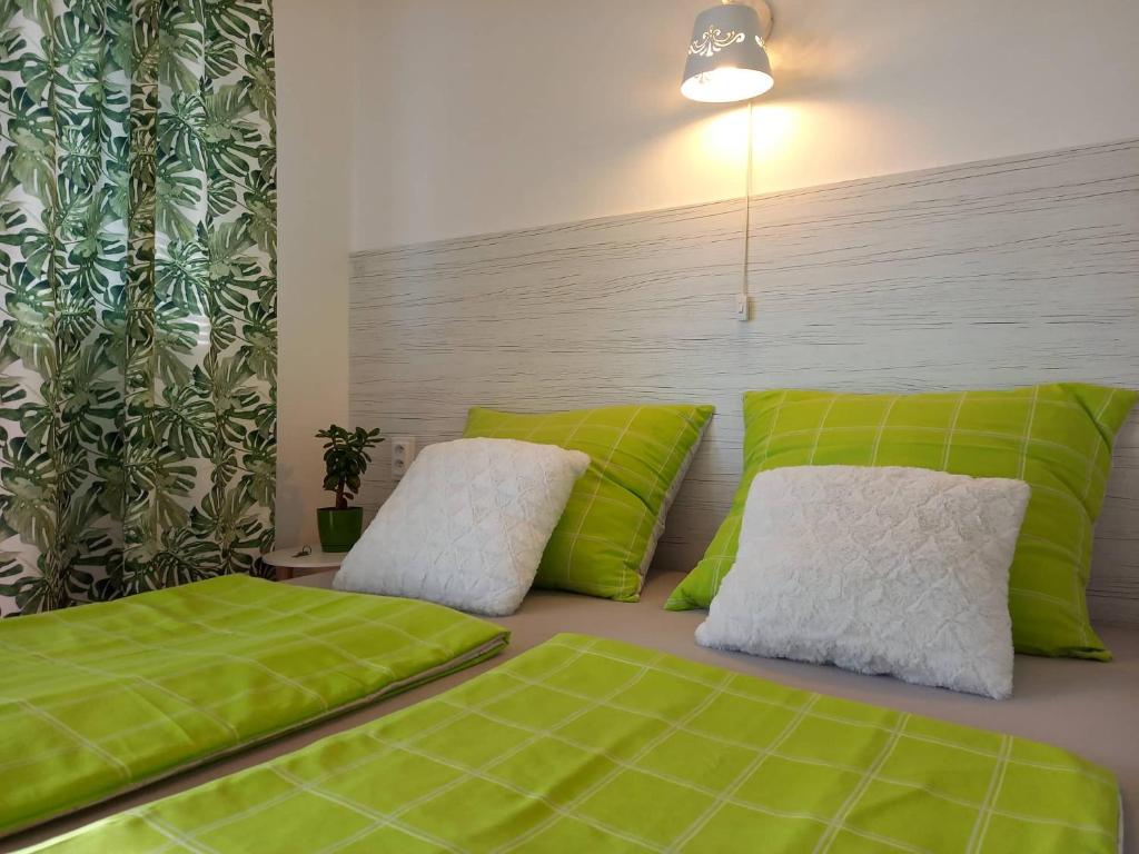una camera da letto con cuscini verdi e bianchi su un letto di Afrodita a Štúrovo