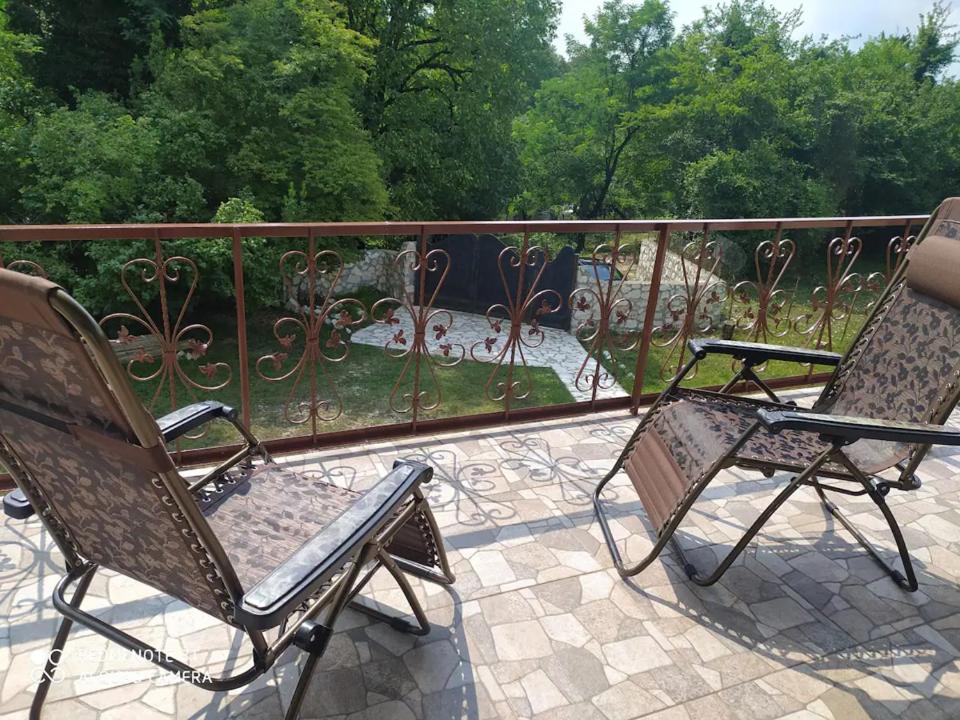 une paire de chaises assises sur un balcon dans l'établissement House at the Forest / სახლი ტყის პირას, à Gordi