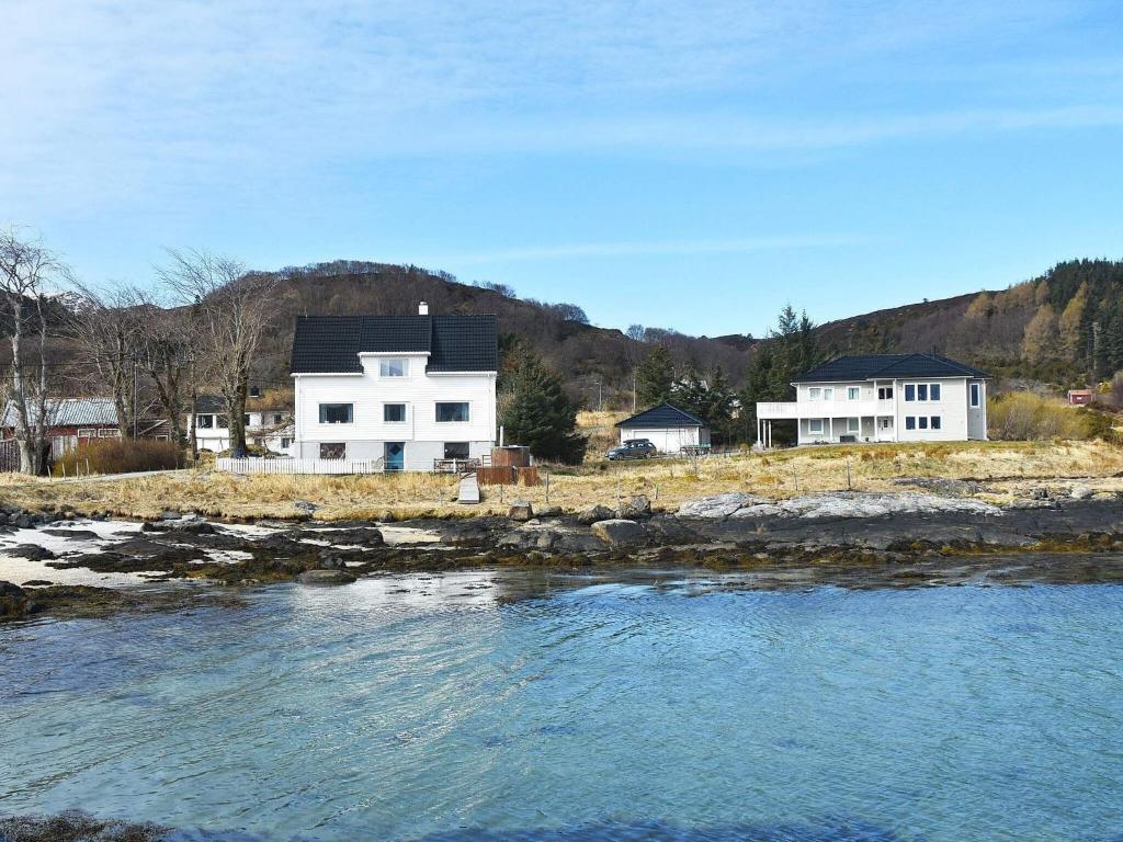 una casa junto a un cuerpo de agua con casas en Holiday home Bølandet, 
