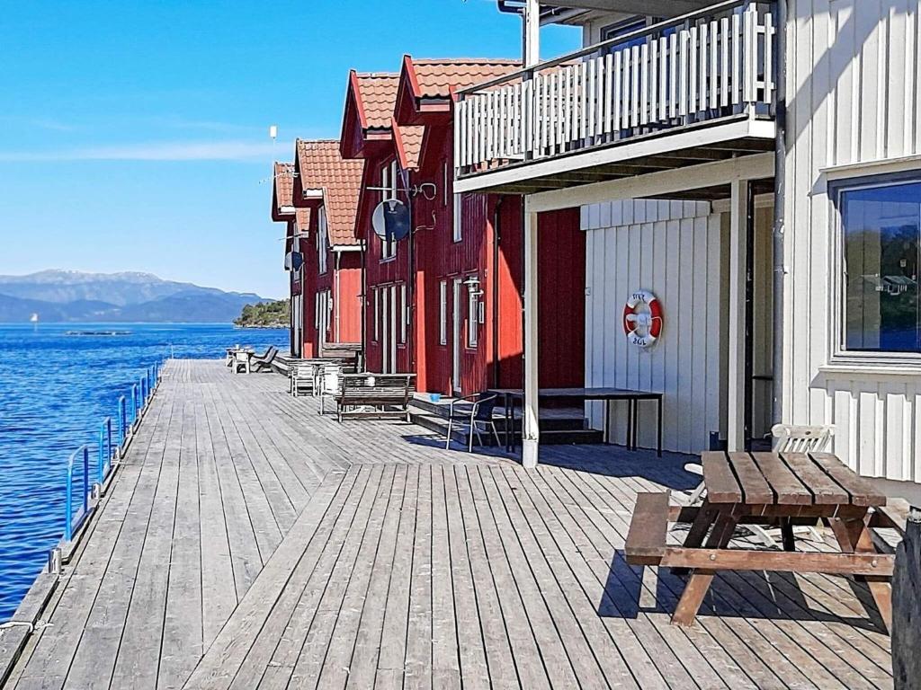 un muelle de madera con un banco junto al agua en Apartment Sjernarøy en Sjernarøy