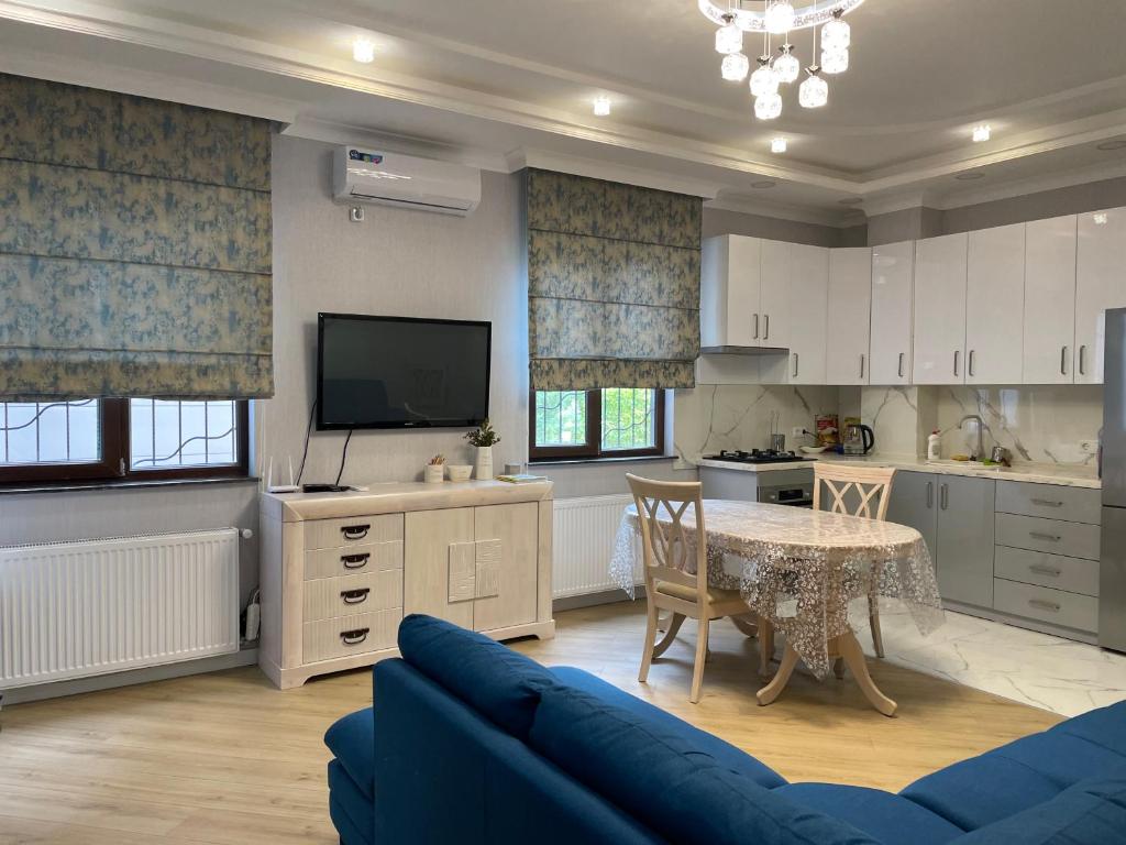cocina con sofá azul, mesa y TV en City Centre Apartment en Kutaisi