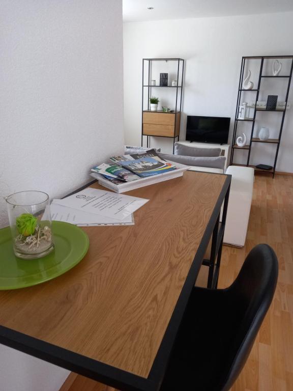 una mesa de madera con un plato verde encima en Ferienwohnung Salzmannhaus, en Zschopau