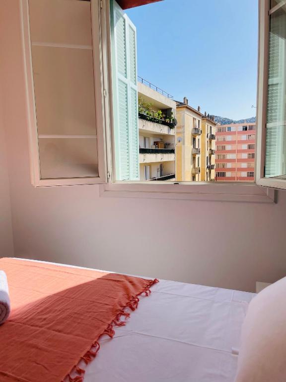 a bedroom with a bed and an open window at Appartement Bonaparte centre ville d&#39;Ajaccio in Ajaccio