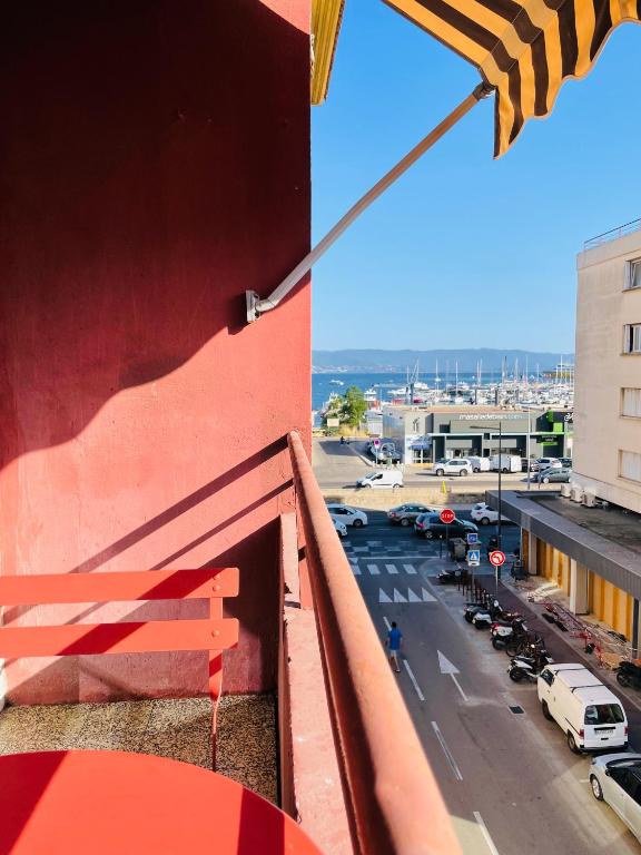 a view of a street from a balcony with an umbrella at Appartement Bonaparte centre ville d&#39;Ajaccio in Ajaccio
