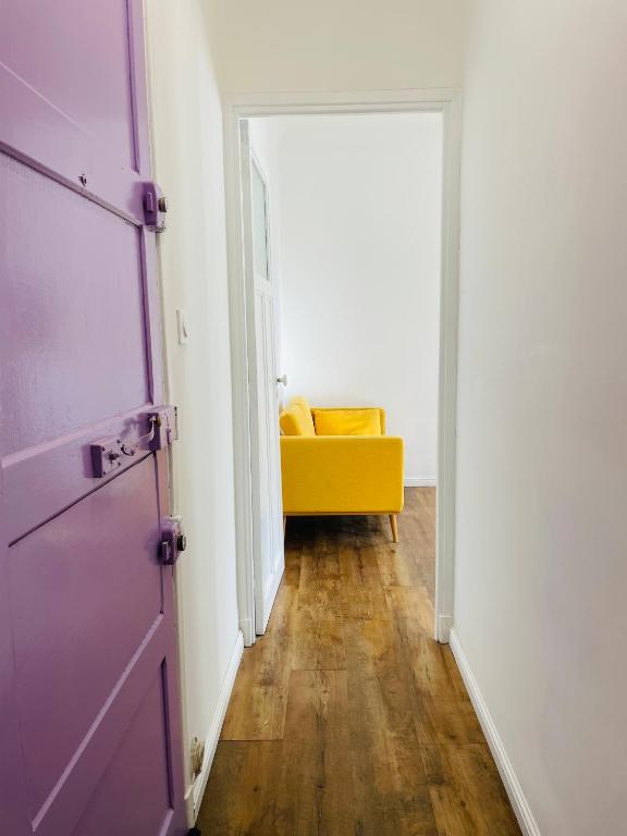 a hallway with a purple door and a yellow couch at Appartement Bonaparte centre ville d&#39;Ajaccio in Ajaccio