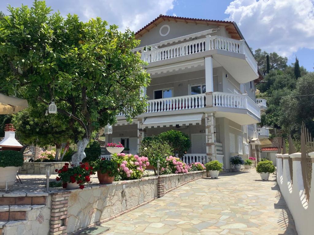una gran casa blanca con flores delante en villa verleti en Parga