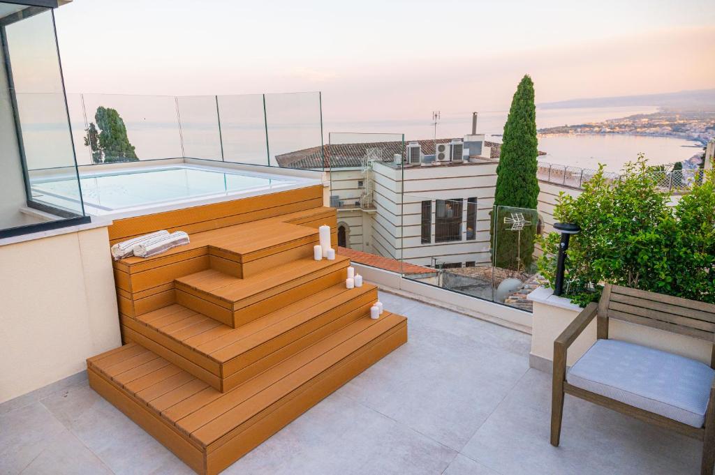 陶爾米納的住宿－Naxi Suites，一个带游泳池和房子的阳台