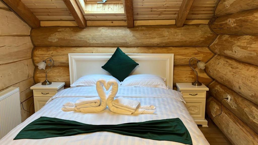 two towel animals sitting on a bed in a cabin at Pensiunea Mireasma Bucovinei in Crucea