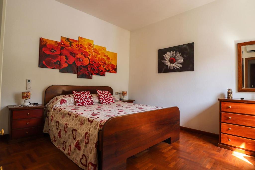 a bedroom with a bed and two paintings on the wall at Margherita Guest House in Coreglia Ligure