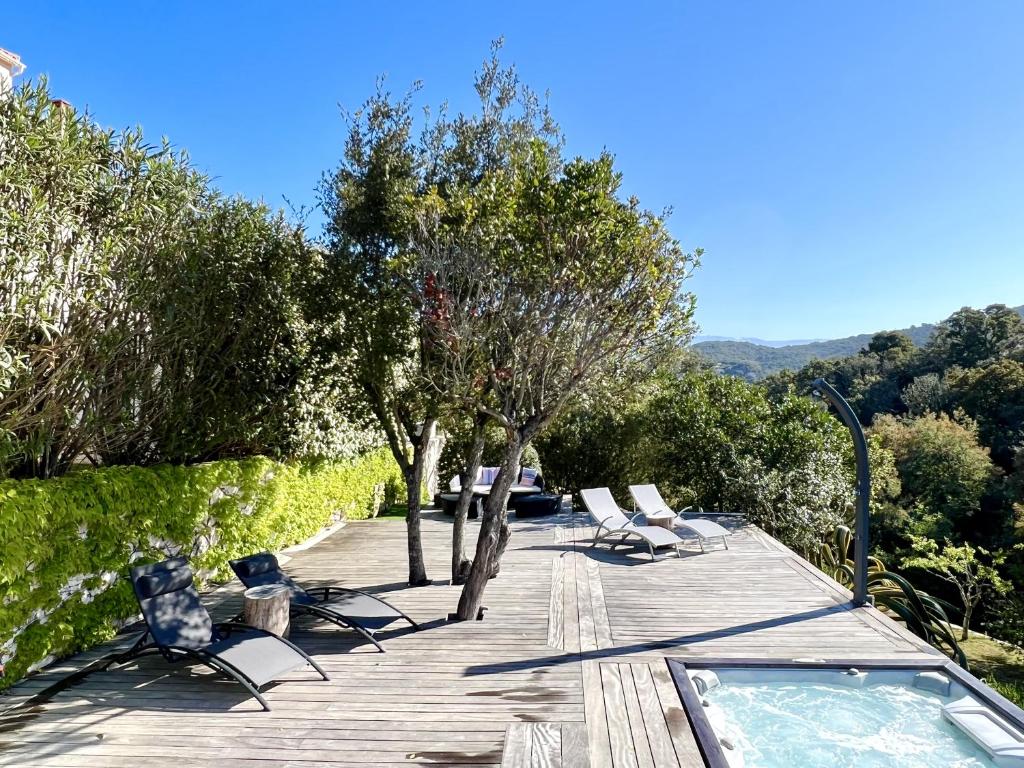 a deck with lounge chairs and a swimming pool at F2 avec jacuzzi, pétanque, à 3 min mer, dans grande propriété in Porticcio