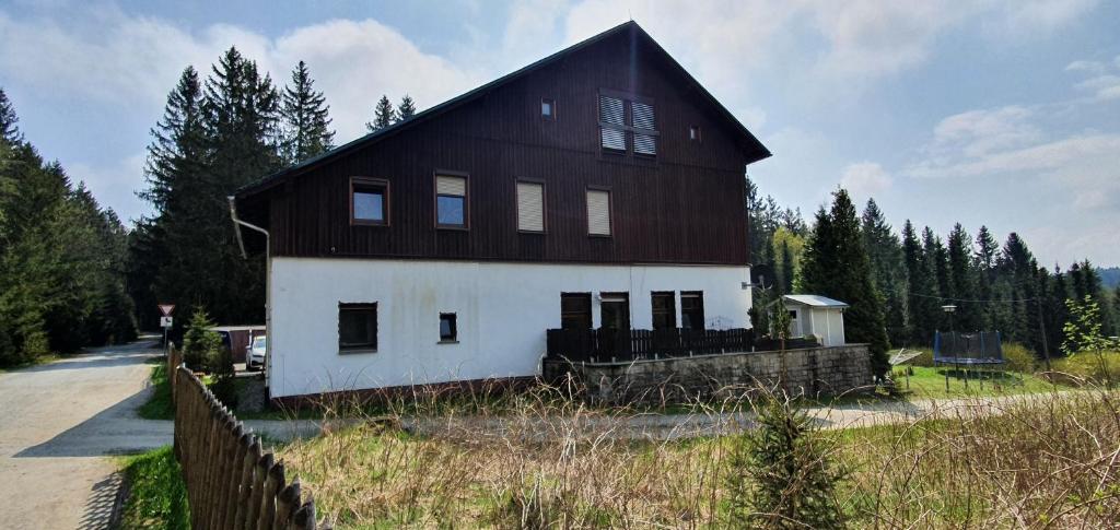 a large black and white barn with a fence at ERZGRÜN - Aktiv und entspannt im Grünen in Neue Welt