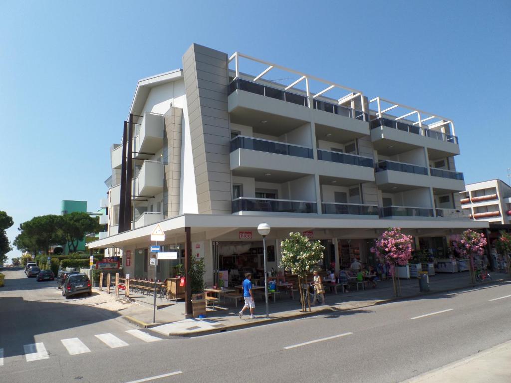 a building with people standing in front of it on a street at Condominio Shedir in Bibione