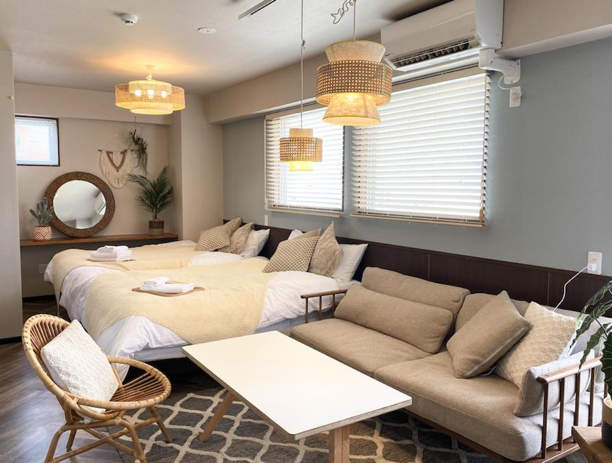 a living room with two beds and a couch at TOMMY CONDOMINIUM WAKASA 401 in Naha
