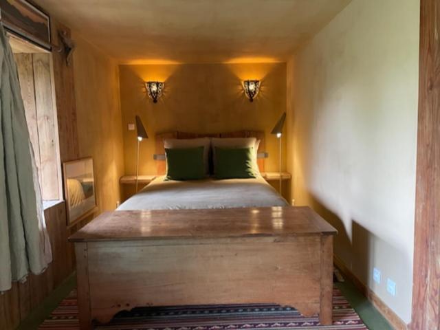 sypialnia z dużym łóżkiem z zielonymi poduszkami w obiekcie au rocher de Combières w mieście Mandailles