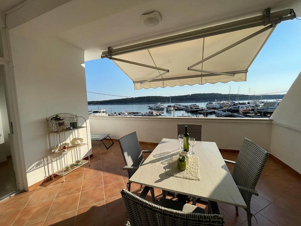 a dining room with a table and chairs and a view of a harbor at Apartments Near the sea Barbat in Barbat na Rabu