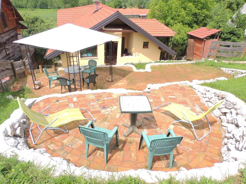 a patio with chairs and a table and umbrella at Apartment Studio Mrežnički Brig in Duga Resa