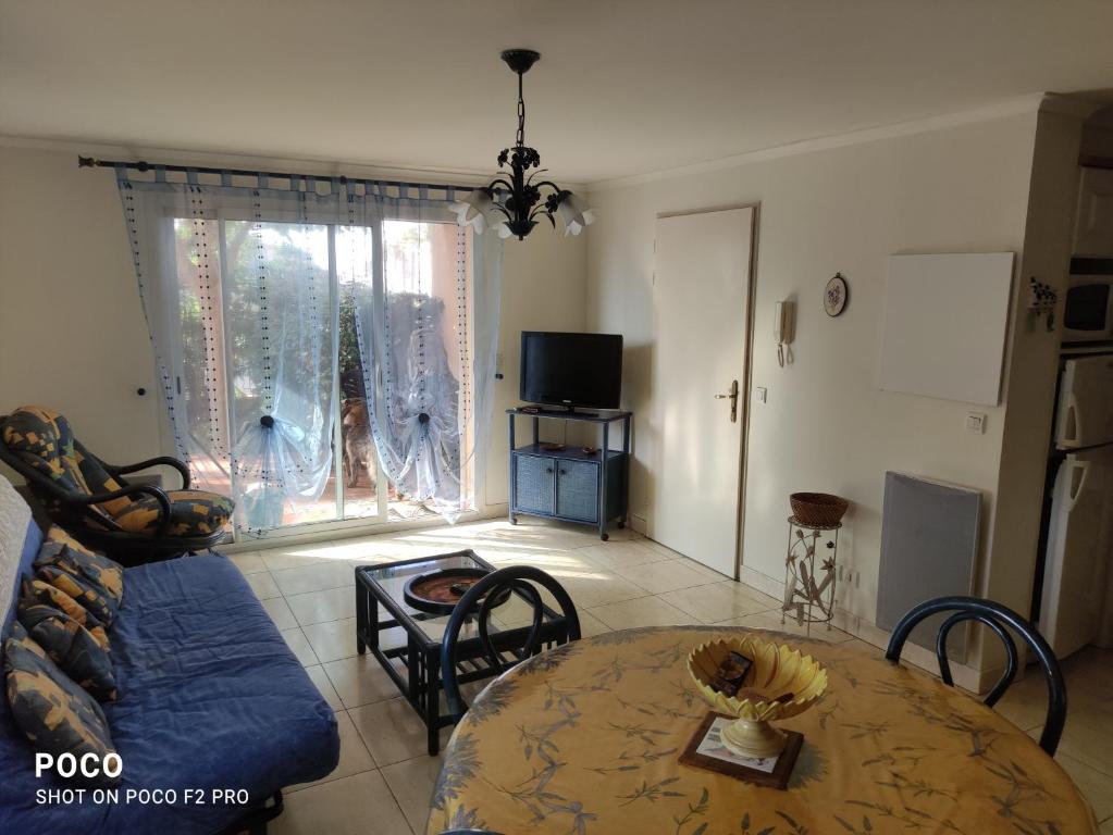 ein Wohnzimmer mit einem Tisch und einem Sofa in der Unterkunft Les jardins d'armand in Valras-Plage