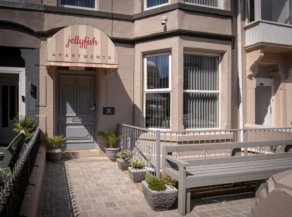 a building with a bench in front of a store at Jellyfish Apartments in Blackpool