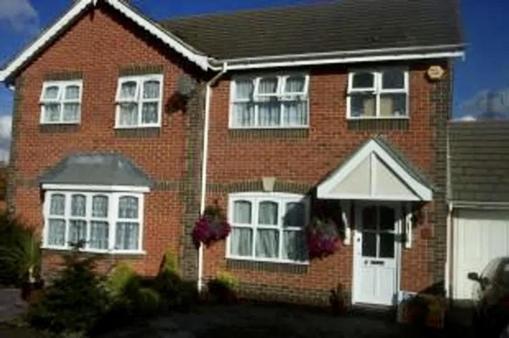 ノース・スティフォードにあるLovely 3-Bed House in Chafford Hundredの白い窓と白いドアが特徴のレンガ造りの家