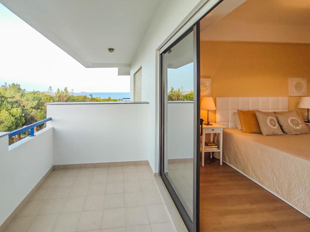 sypialnia z łóżkiem i widokiem na ocean w obiekcie Apartamento Gomes -Free Airco, wiffi & Swimming Pool- by bedzy w mieście Porches
