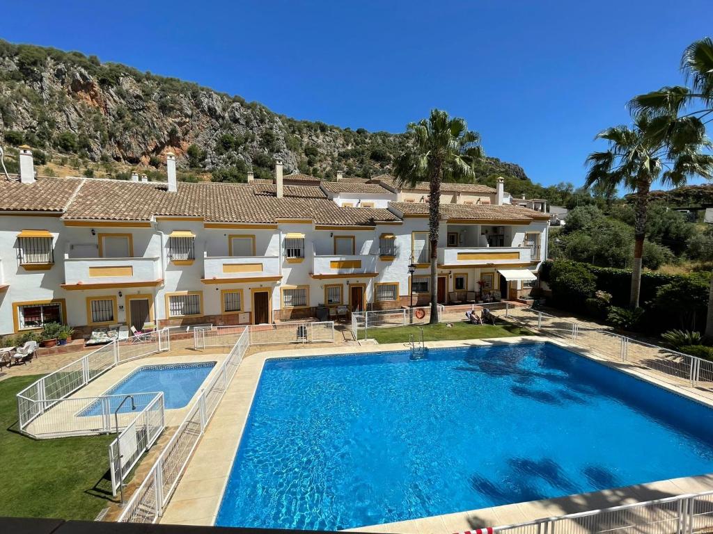 a villa with a swimming pool and a house at Casa Lucía y Clara benaojan in Benaoján