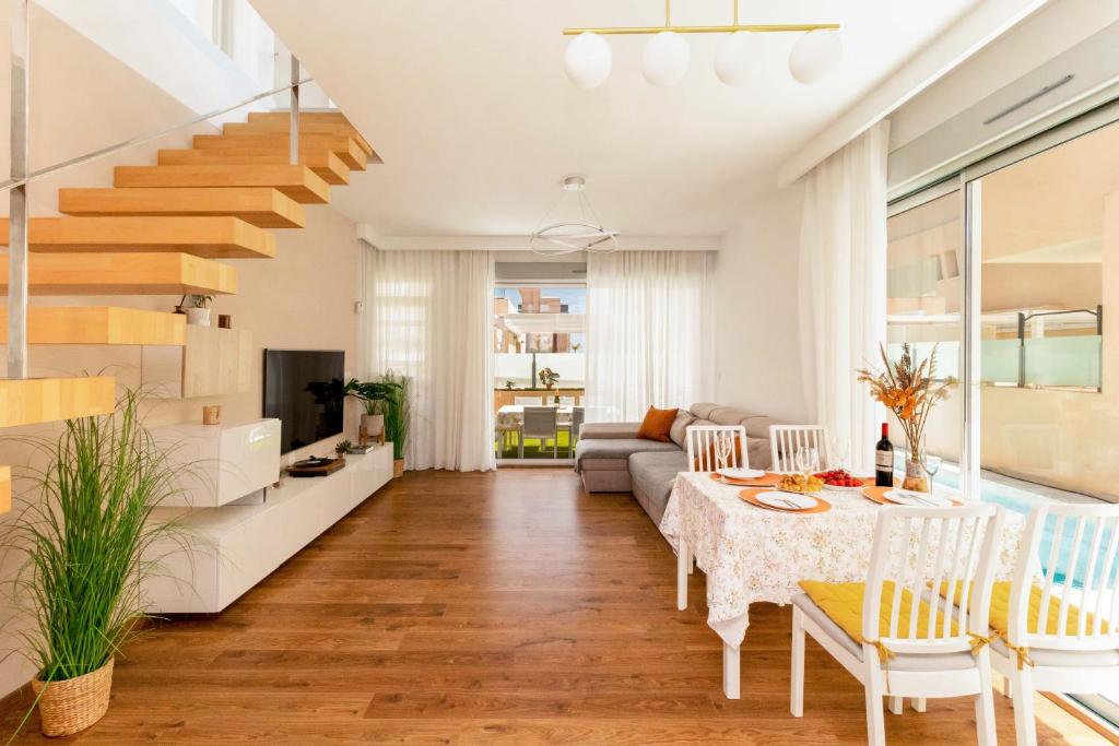 - un salon avec une table à manger et un escalier dans l'établissement Luxurious villa with children's area (5 min to the sea), à La Horadada