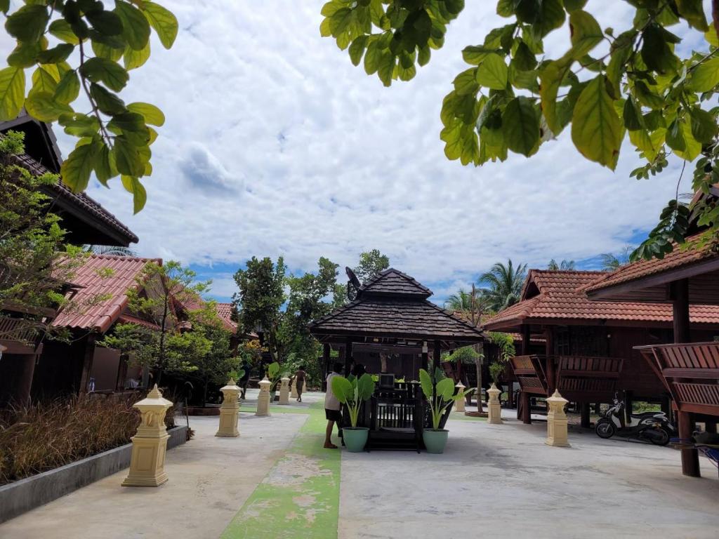 a pavilion in the middle of a courtyard with buildings at Ruenthai Ampawa in Samut Songkhram