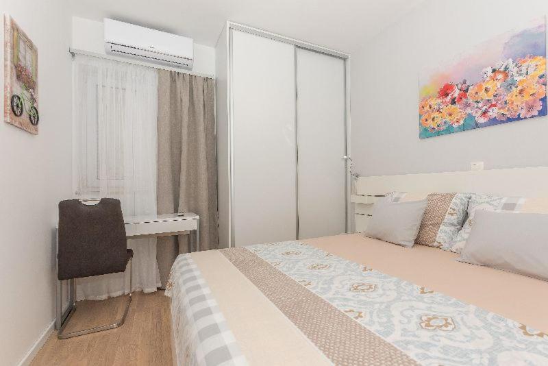 a bedroom with a bed and a desk and a window at Apartment J&J in Makarska