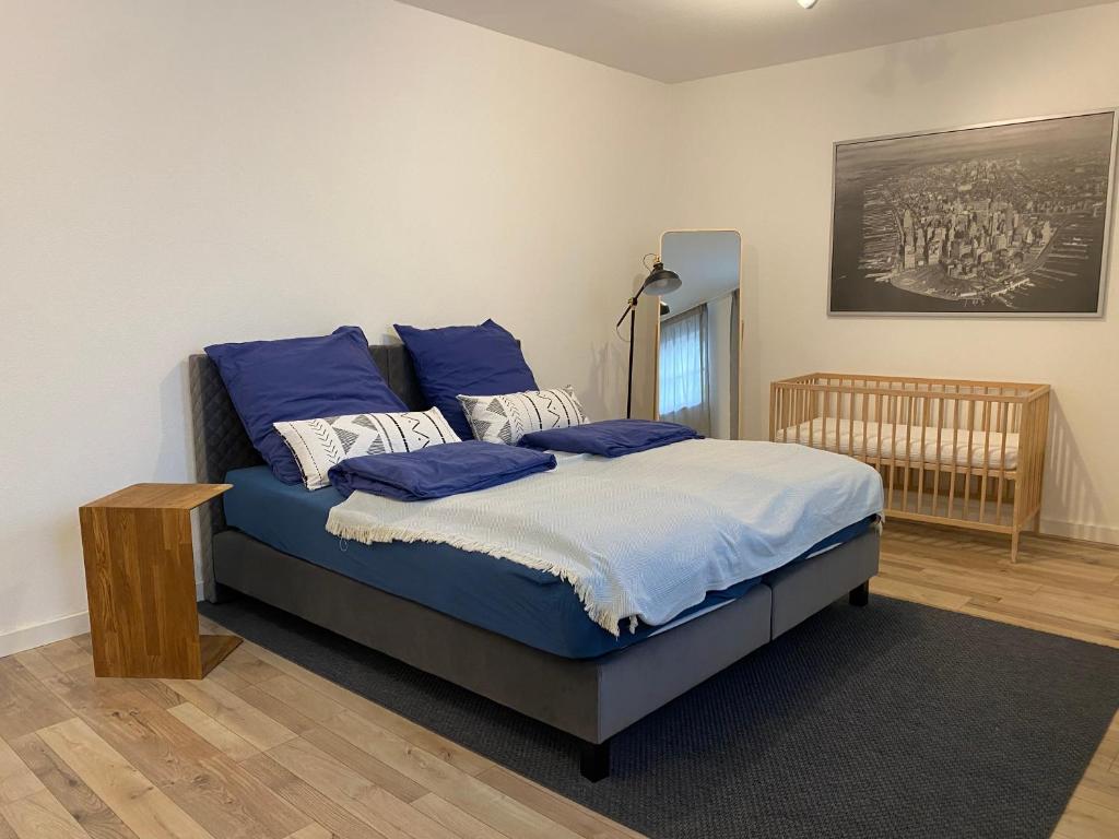 ein Schlafzimmer mit einem Bett mit blauen Kissen darauf in der Unterkunft Ferienwohnung Brötzingen - EG in Pforzheim