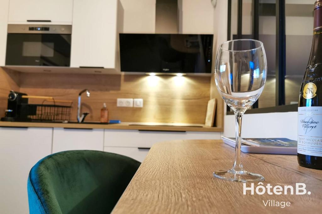 a wine glass sitting on a table next to a bottle of wine at Town Hall Studio - Hyper-center Limoges in Limoges