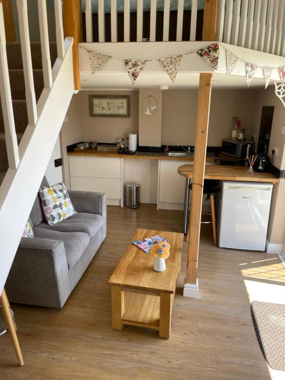 sala de estar con cama elevada y cocina en Hideaway, en Bradford on Avon