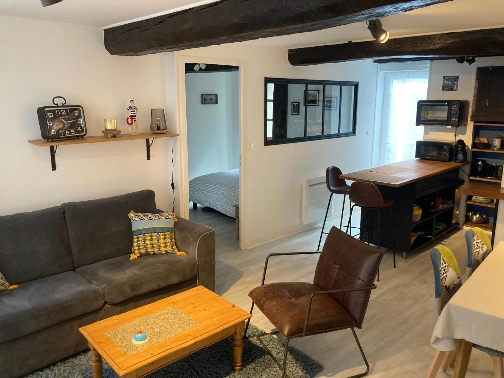 a living room with a couch and a piano at Appartement Haute Ville meublé avec cour privative in Granville