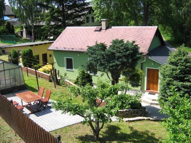 una casa verde con una mesa y sillas en un patio en Fidler, en Rozvadov