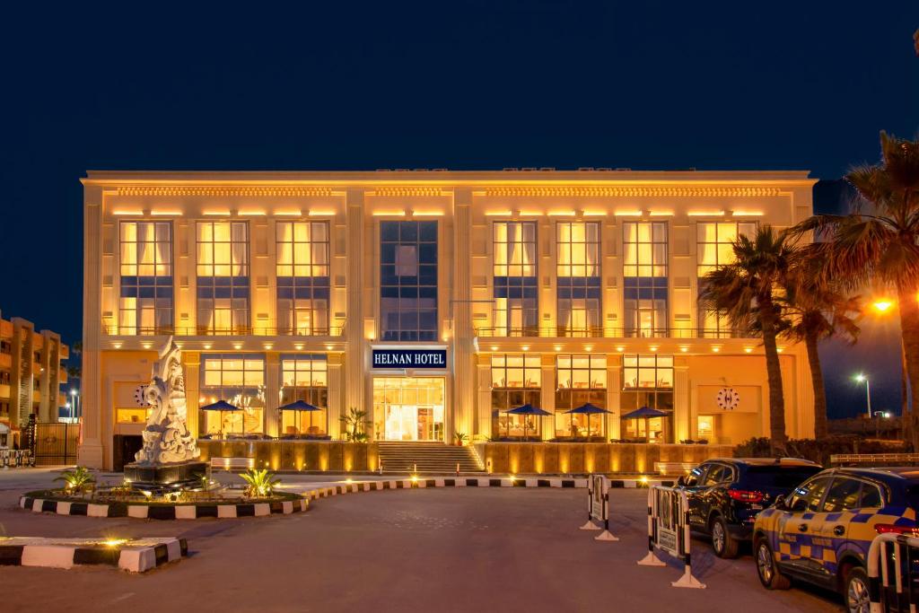 un gran edificio con coches estacionados frente a él en Helnan Mamoura Hotel & Events Center, en Alejandría