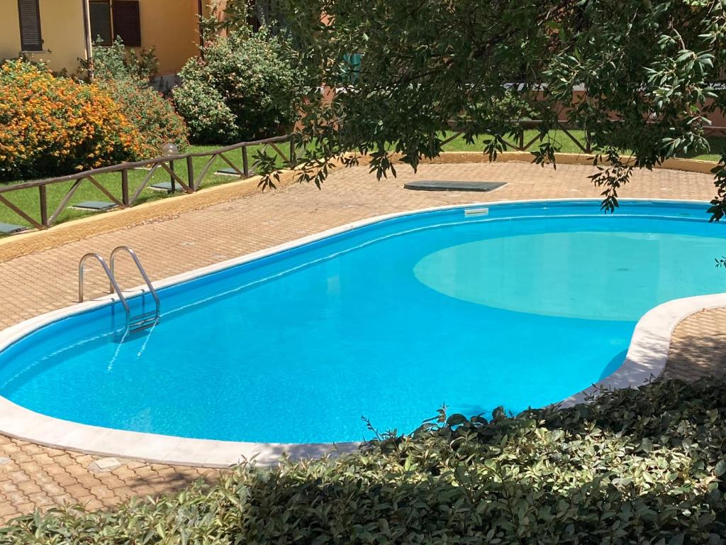 a large blue swimming pool in a yard at La Marina Apartment with Pool in Olbia