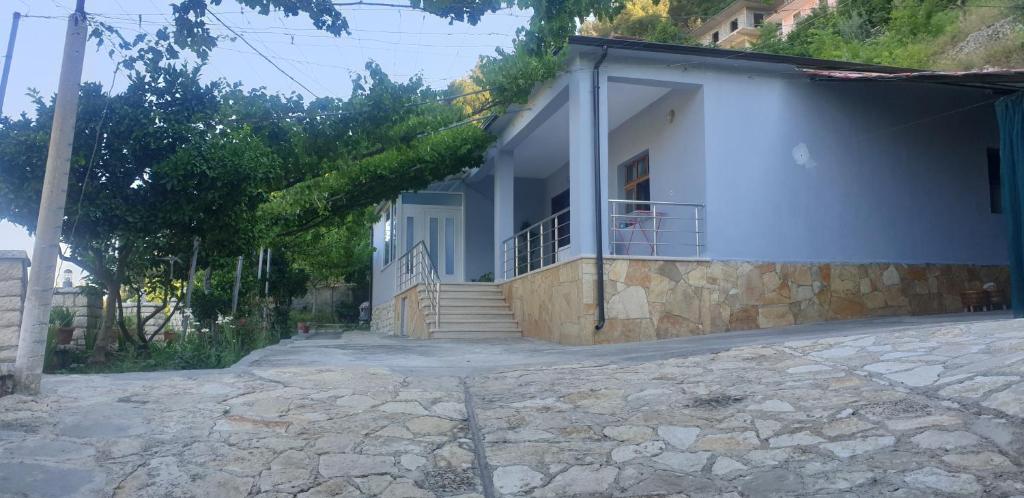 a white house with stairs and a balcony at Green Forest in Berat