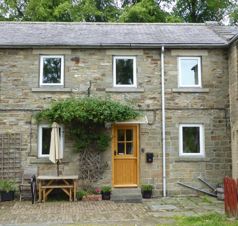 Cabaña de piedra con puerta de madera en Mews Cottage, en Middleton in Teesdale