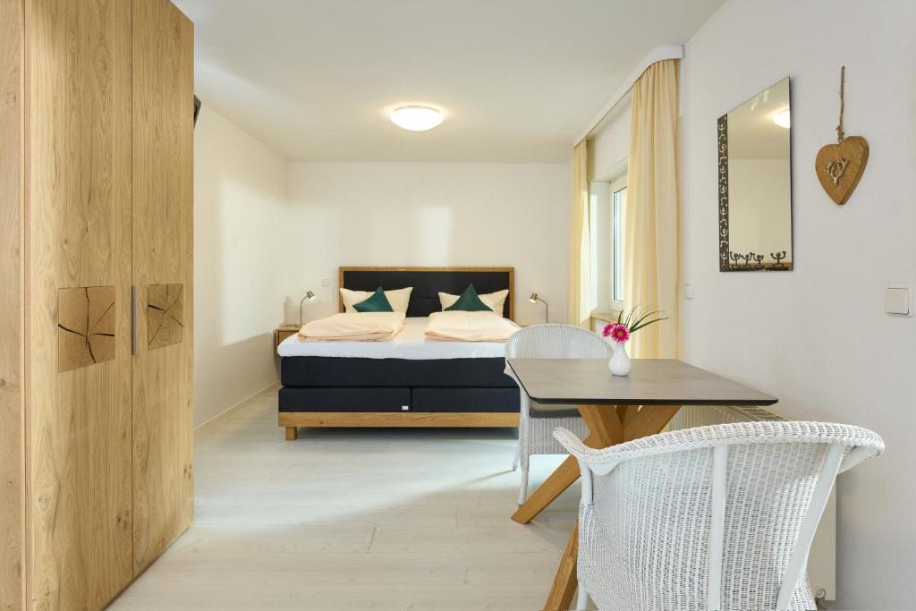 a bedroom with a bed and a table and a chair at Thermen Appartements Gabriela, Appartement 24 qm in Bad Krozingen