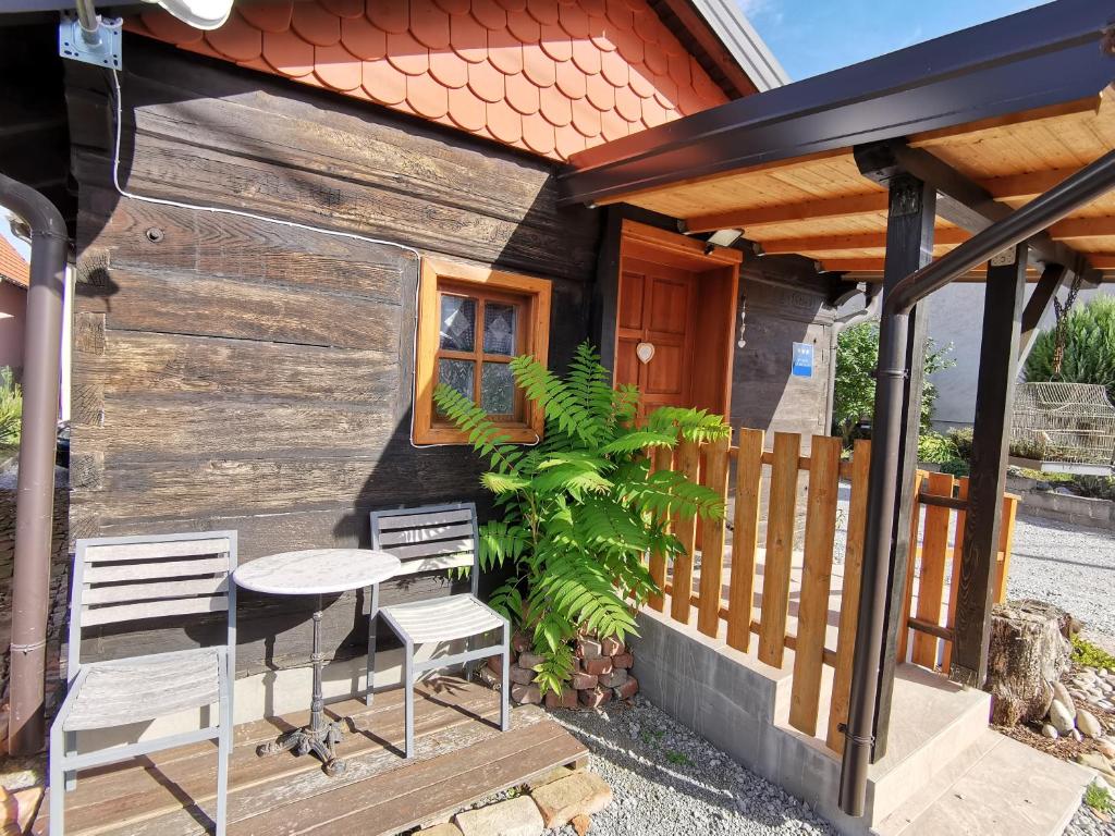 a tiny house with a table and chairs on a porch at Studio Apartment Romeo in Velika Gorica