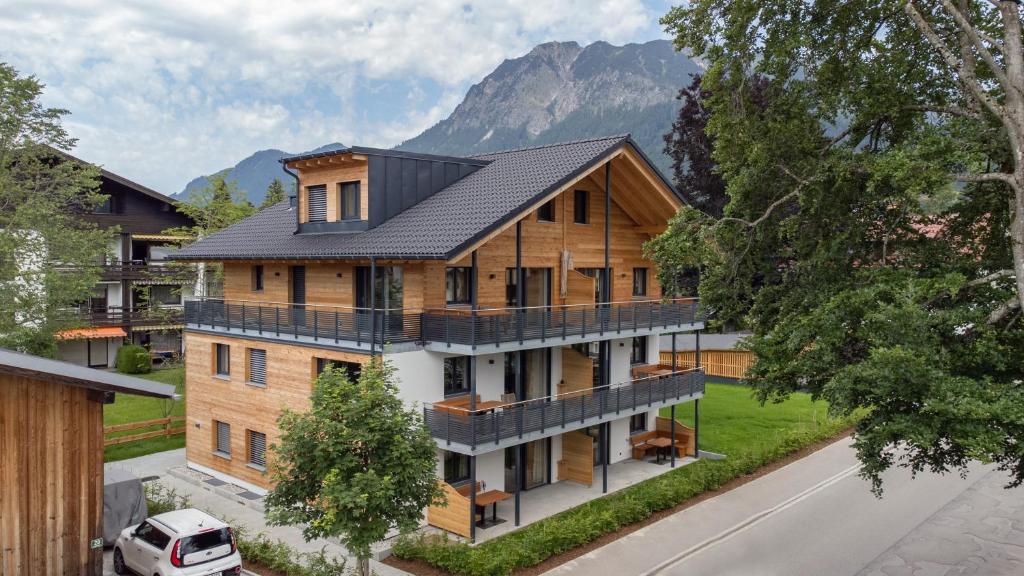 an aerial view of a house with mountains in the background at Dorf Suites in Oberstdorf