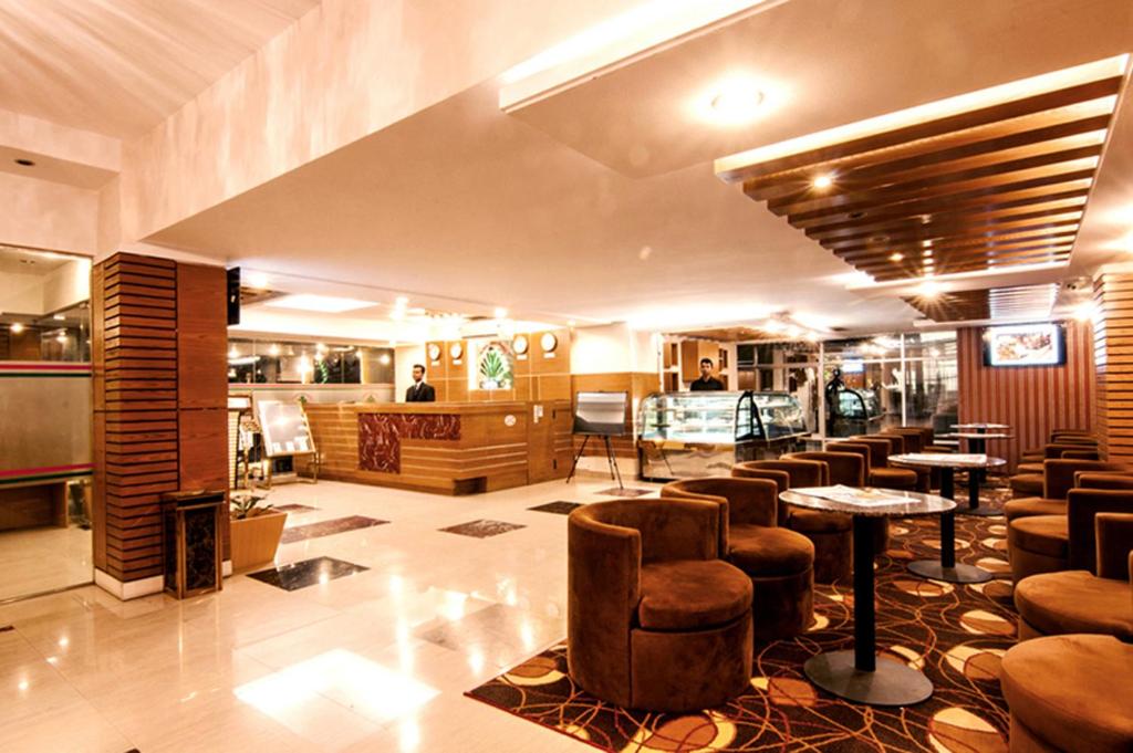 un restaurante con un bar con mesas y sillas en Century Park Residence, en Dhaka